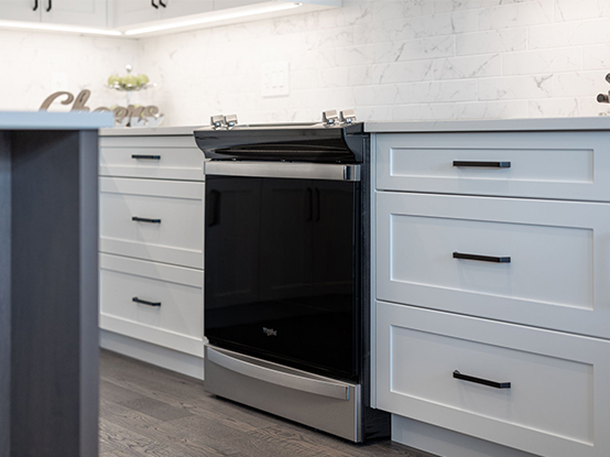 Close up of stove, with spacious drawers on either side, in a model home kitchen.