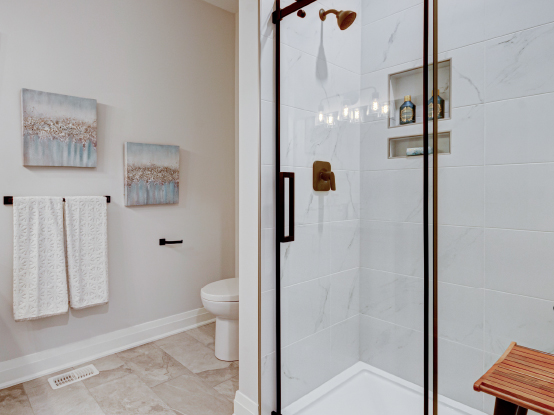 Tiled shower enclosure accented with black trim and fixtures.